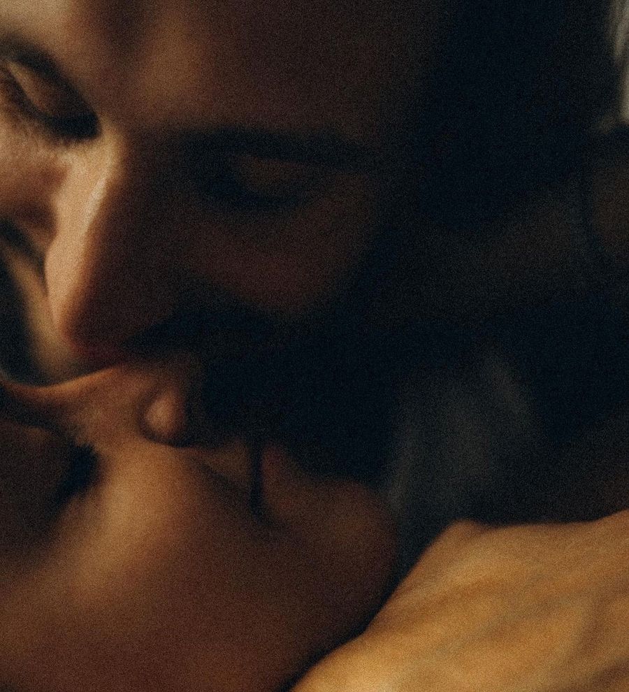 A couple resting cheek to cheek in warm low light