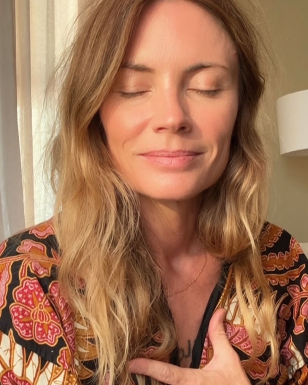 Rachel with eyes closed and a hand resting on her heart