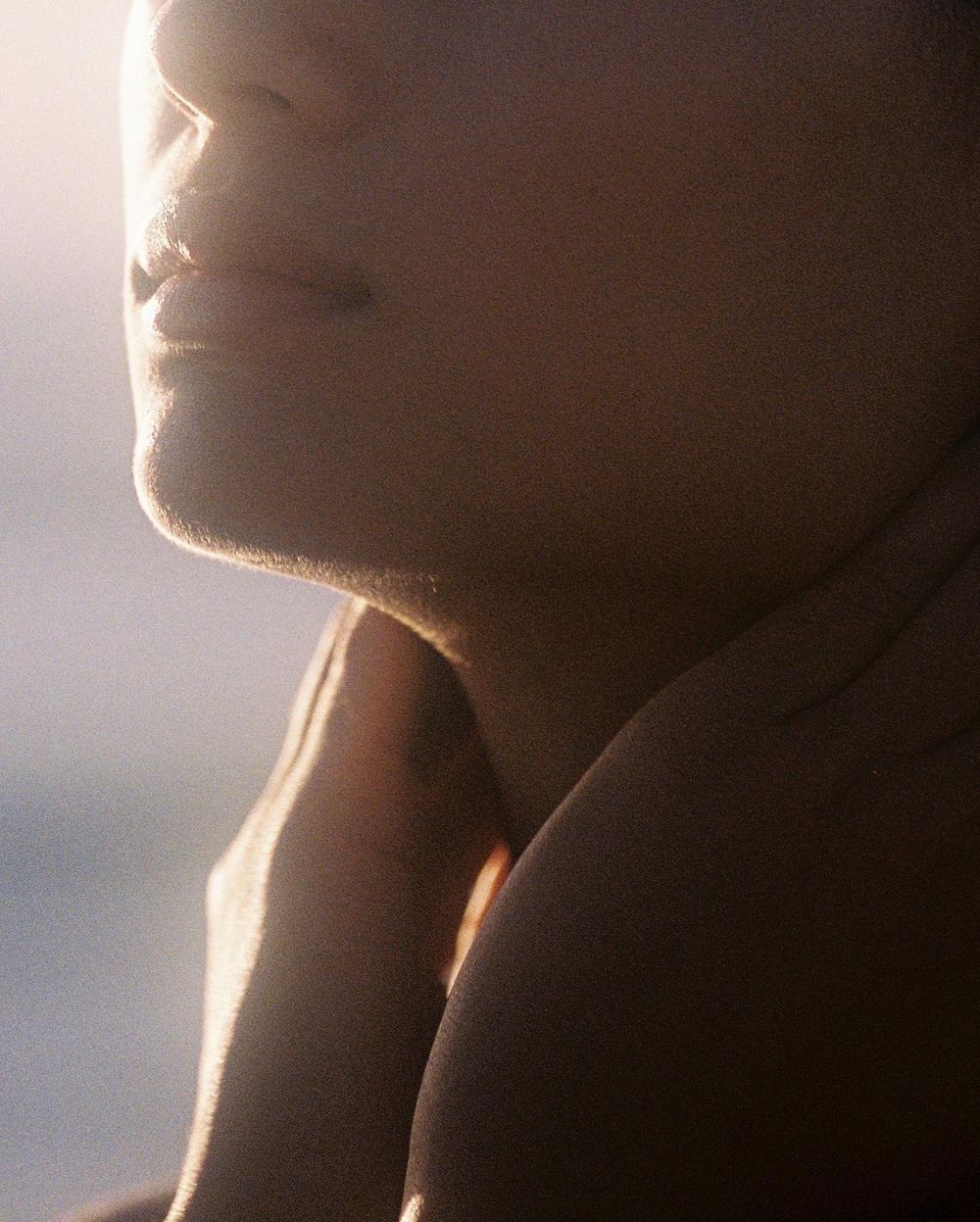 Sunlight along a woman's jaw and shoulder